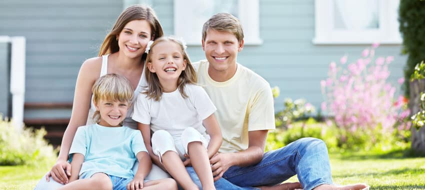 AC Maintenance Mother, father, son, and daughter pose outside their home on grassy yard on bright summer day.