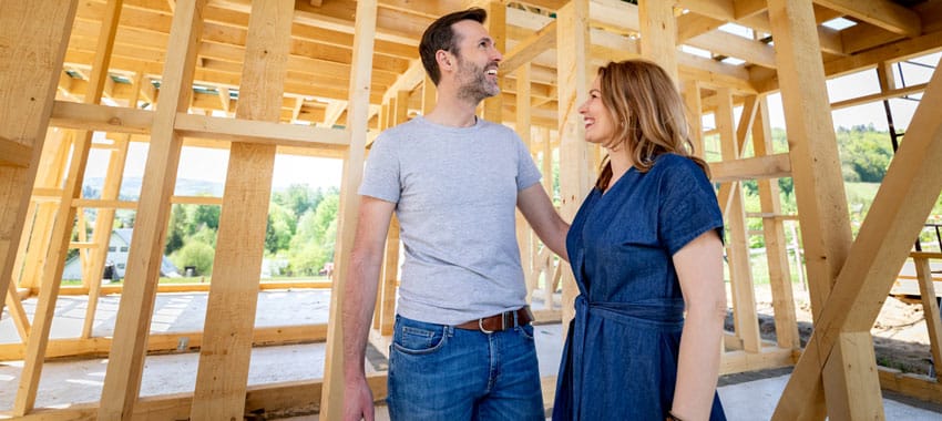 Husband and wife walk through new construction of their home before walls are put up.